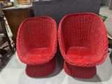 pair of red wicker chairs with matching foot stools