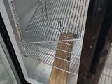 a small open refrigerator with a wooden stick sticking out of it ' s door
