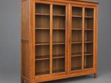 une bibliothèque en chêne avec des portes vitrées