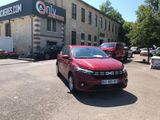 a red car parked in front of a building in a parking lot