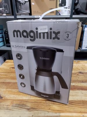 La boîte d'une cafetière est posée sur une table en bois.