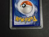 the pokemon card is in a plastic holder on a table