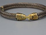 un gros plan sur un bracelet en corde muni d'un fermoir en or