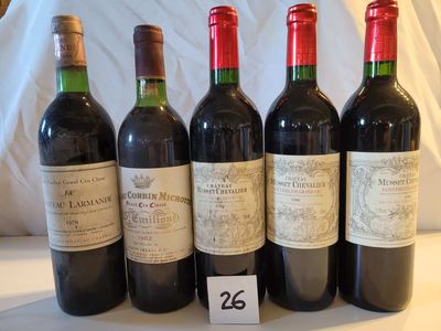 quatre bouteilles de vin rouge sont alignées sur une table