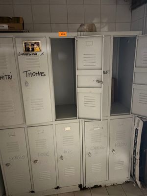 many white lockers in a room with graffiti on them