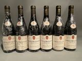 six bottles of wine are lined up in a row on a table