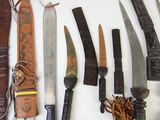 many different types of knives and knives laid out on a table