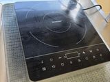 a stove top with a black burner on it in a kitchen