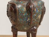 a small vase with an elephant on it on a table