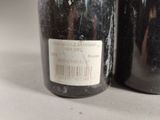 two bottles of wine sitting next to each other on a table