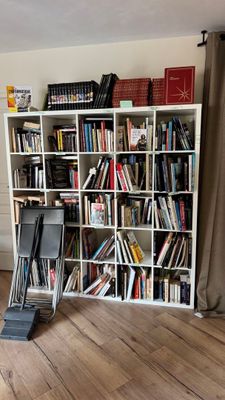 une bibliothèque remplie de livres, placée dans un coin de la pièce