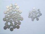 a lot of silver coins on a white surface