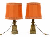 une paire de lampes orange posées l'une sur l'autre sur une surface blanche