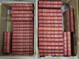 de nombreux livres rouges dans une boîte posée par terre