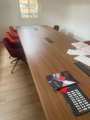 une longue table en bois sur laquelle est posée une télécommande