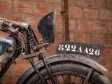 a old motorcycle parked in front of a brick wall