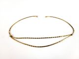un gros plan d'un collier ras-du-cou en or sur fond blanc