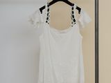 an image of a white top hanging on a hanger