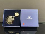 une pièce d'or dans une boîte bleue posée sur une table noire