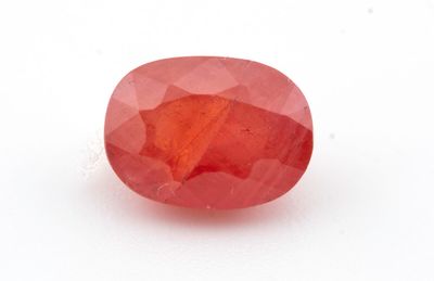 une pierre ovale de couleur rouge rubis sur fond blanc