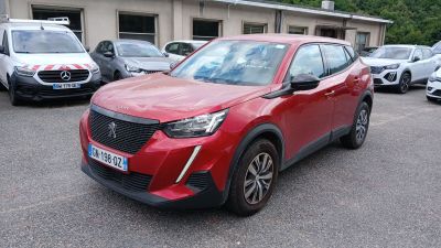 une voiture rouge garée dans un parking à côté d'autres voitures