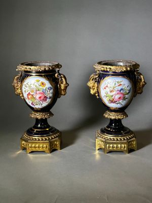 pair of antique vases with painted flowers on them sitting on a table