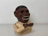 une petite statue représentant un homme avec un grand sourire