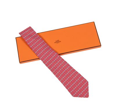 La cravate est rouge et blanche, avec un motif.