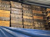 many stacks of wooden boxes stacked on top of a blue tarp