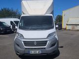 une camionnette blanche garée sur un parking à côté d'un bâtiment