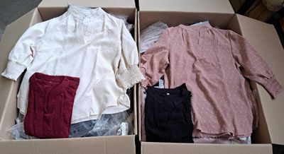 two boxes with clothes in them sitting on a table