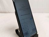 a close up of a cell phone on a stand on a white surface