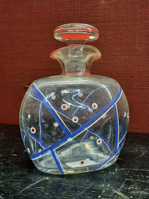a clear glass bottle with a blue and red design on it