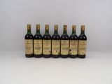 six bouteilles de vin alignées sur une surface blanche