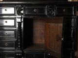 a black dresser with a mirror and a vase on top of it
