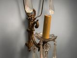 a candle that is on the wall next to a wall sconce