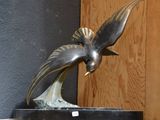 une statue représentant un oiseau perché sur une table