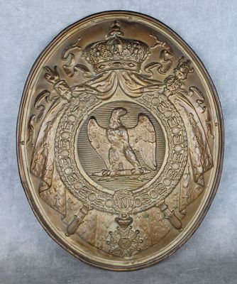 une image représentant une assiette en or sur laquelle figure un aigle