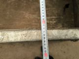 someone is measuring the length of a piece of metal with a ruler