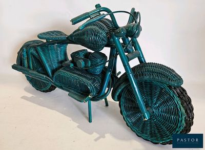 a green wicker motorcycle that is sitting on a table