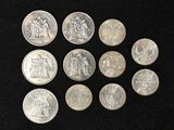 six types différents de pièces d'argent sur une surface noire