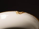 a close up of a white bowl with a brown spot on it