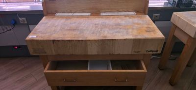 a wooden table with drawers on it in a kitchen