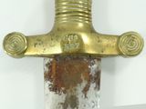 a close up of a sword on a white surface