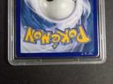 a pokemon card in a plastic case on a table