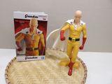 toy figurine of a man in a yellow outfit standing next to a cardboard box