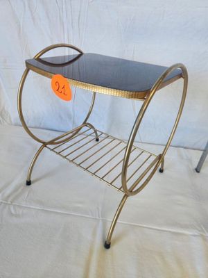 a metal table with a glass top and a magazine rack