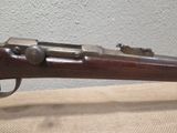 a close up of a rifle on a table with a wall in the background