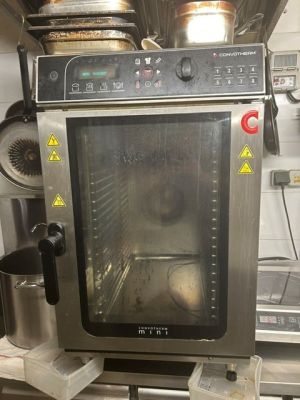 un four dans lequel se trouve un poulet, dans une cuisine