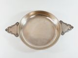 an antique silver plate with a handle on a white background